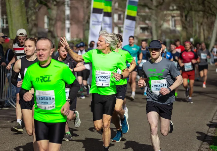 Groep hardlopers in groene shirts tijdens een wedstrijd