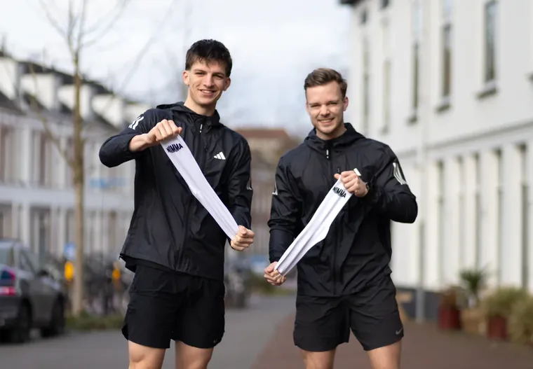 Twee hardlopers met hun sportmateriaal in de stad