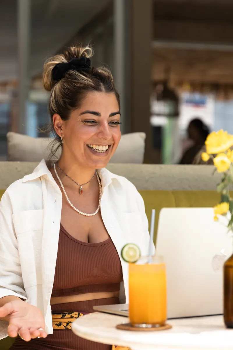 Lifecoach lachend achter haar laptop tijdens een personal-brandingshoot