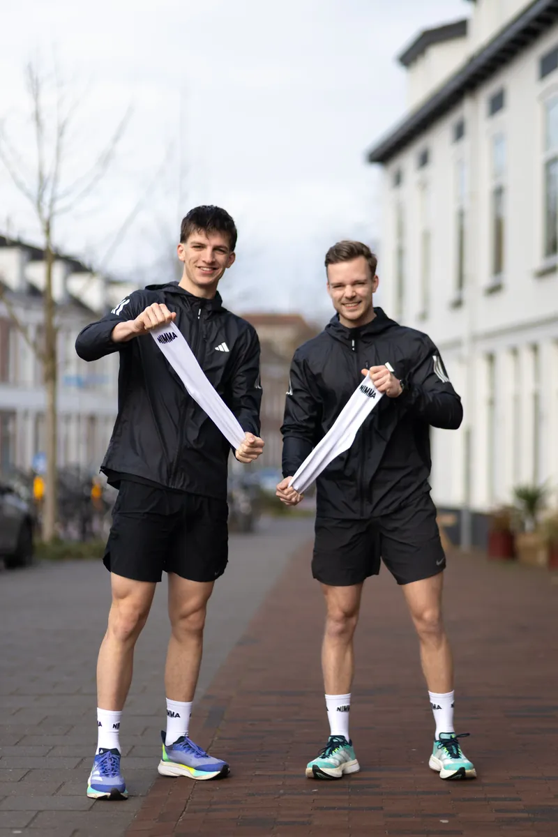 Twee hardlopers in de stad met de sokken van Nimma Running Club