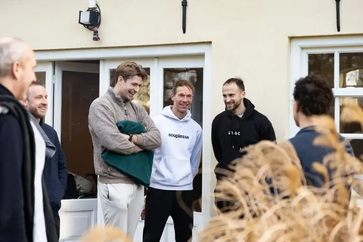Een moment van ontspanning tussen de oefeningen door, de groep maakt grapjes bij de openslaande deuren