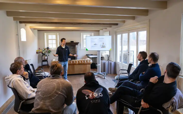 Eventfotografie van de Chakana Coaching workshop, de groep zit in een halve kring terwijl de coach vertelt