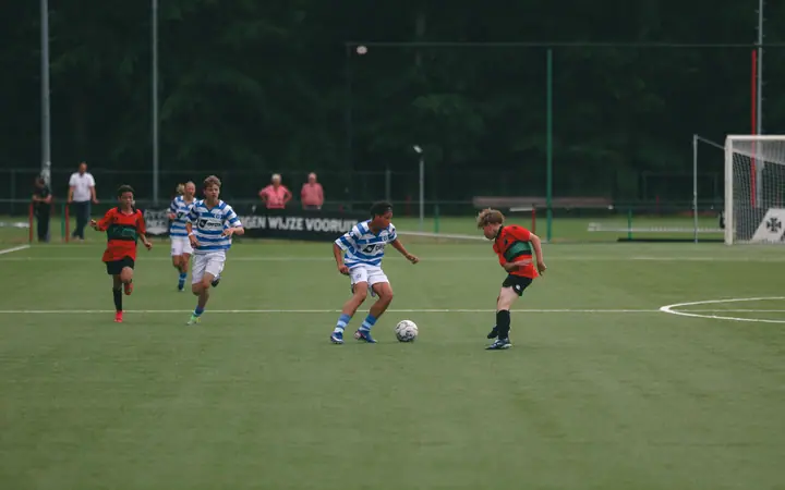 Speler van De Graafschap drijft de bal op door het middenveld, een NEC-speler komt hem tegemoet