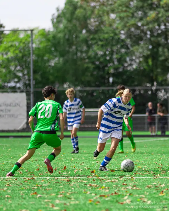 Speler met paardenstaart van De Graafschap dribbelt weg van nummer 20 in het groen