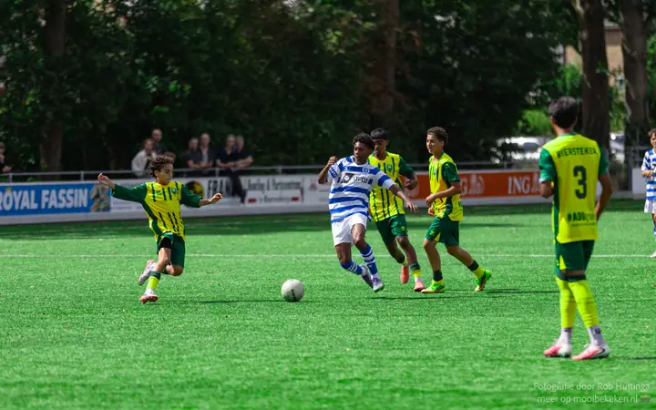 Speler van De Graafschap zoekt een opening tussen vier tegenstanders in geel-groene shirts