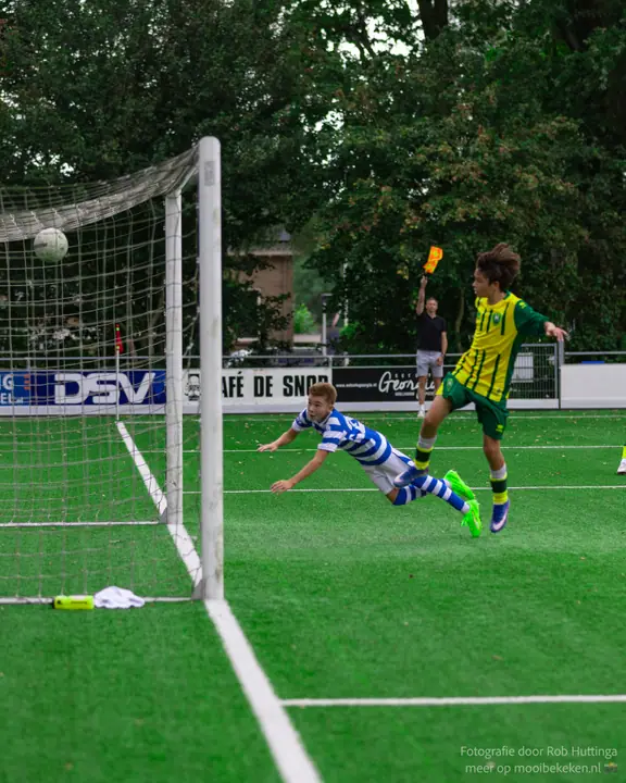 Duikende kopbal van een jeugdspeler van De Graafschap, de bal ligt al in het net