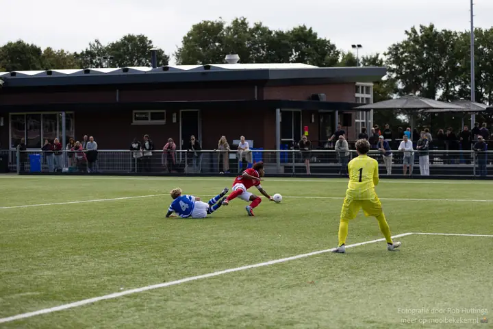 Speler in rood struikelt over nummer 4 van De Graafschap, de keeper in geel staat klaar