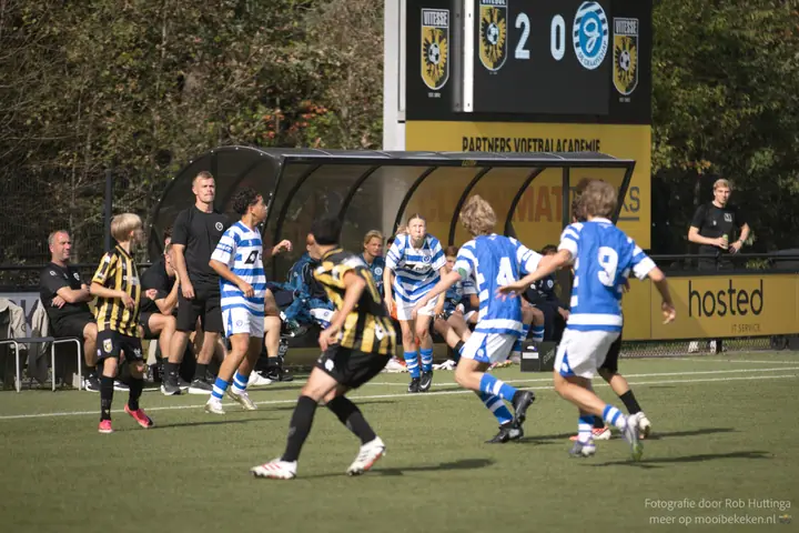 Spelers van De Graafschap voor de dug-out bij Vitesse, met 2-0 op het scorebord erboven