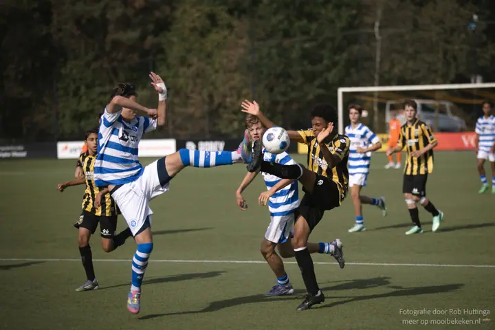 Hoog been in de lucht, een speler van De Graafschap en een Vitesse-speler gaan samen naar de bal