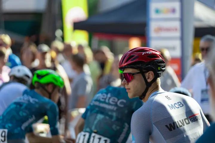 Renner met rode helm en roze zonnebril wacht geconcentreerd op de start van het NK Wielrennen 2026