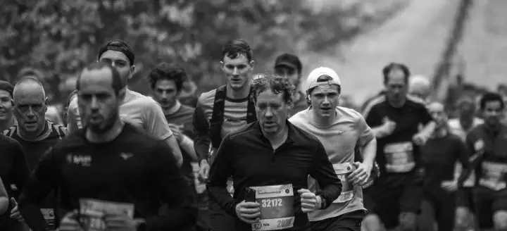 Zwart-wit beeld van een groep geconcentreerde lopers op de Zevenheuvelenloop in Nijmegen